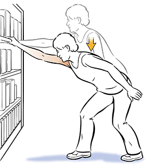 Woman doing shoulder elevation exercise, holding onto bookcase. 