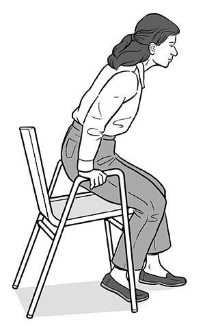 Woman holding armrests of chair and keeping back straight as she sits down.