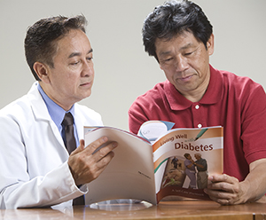 Hombre y médico observando el manual sobre diabetes.