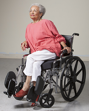 Mujer en una silla de ruedas inclinada hacia el lado para sacar presión de una pierna.