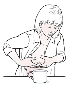 Una mujer se extrae leche con la mano.