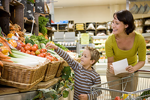 Mujer y un niño pequeño de compras en un supermercado.