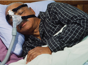El hombre está en la cama y lleva una máscara CPAP.