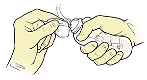 Una mano con guante aprieta la pera vacía del tubo de drenaje mientras la otra mano limpia la parte superior.